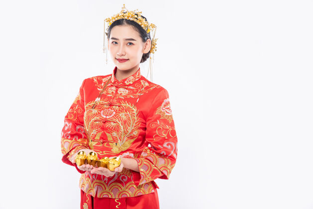 中国新年女人穿旗袍西服 戴皇冠 送黄金给家人 祝新年吉祥给予传统服装成人