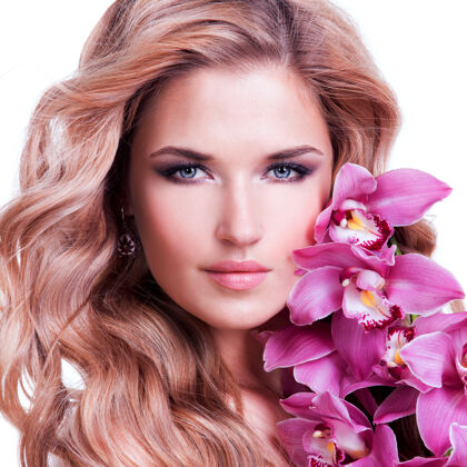 新鲜美丽的女人的脸 健康的皮肤和粉红色的花在白色的墙上美容完美水疗