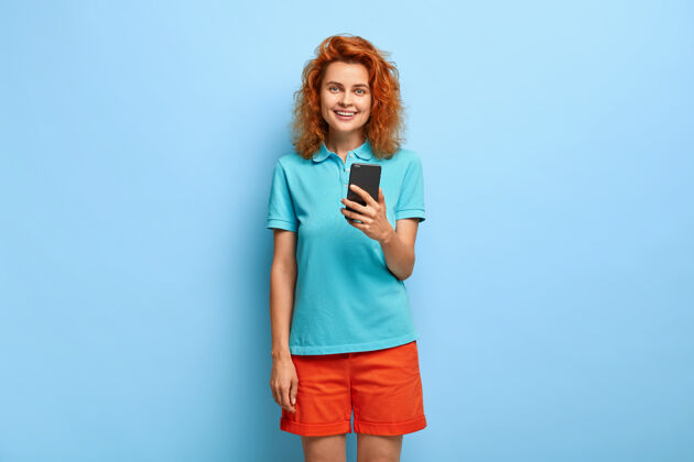 在线美丽红发少女使用智能手机设备 安装新应用程序小工具聊天移动
