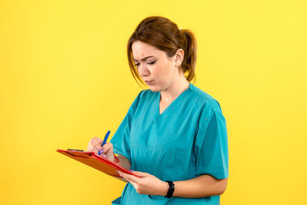 人女兽医在黄色墙上写笔记的正面图女兽医人健康