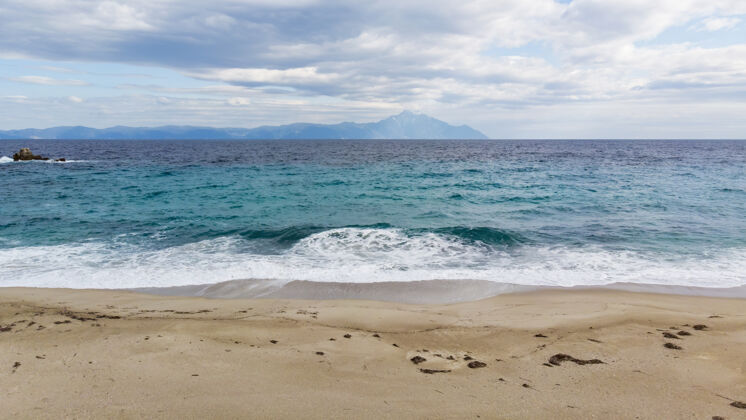 镁砂一个有着爱琴海和山蓝色波浪的海滩海岩石悬崖