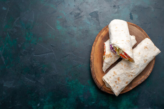 吐痰俯视图肉三明治深蓝色桌子上用烤肉和蔬菜做成的三明治三明治汉堡食物午餐肉照片自制的午餐汉堡包