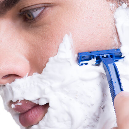 奶油年轻人用剃须刀刮胡子-白色隔离皮肤护理年轻肖像