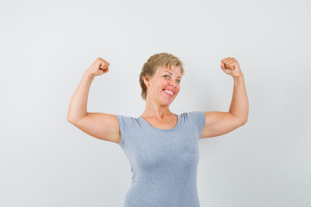 强壮穿着灰色t恤的成熟女性 展现手臂肌肉 看起来很强壮白发成熟灰色