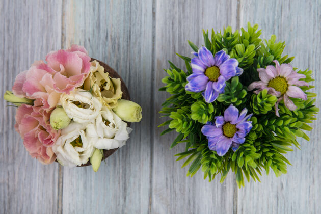 花顶视图五颜六色的惊人的花在一个木碗与雏菊花在灰色的木制背景灰色木头顶部