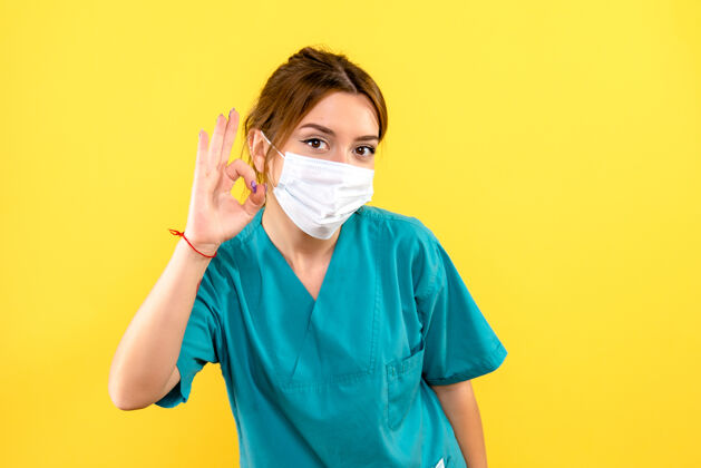 护士黄色墙壁上戴着面罩的女兽医的正视图医疗支持脸