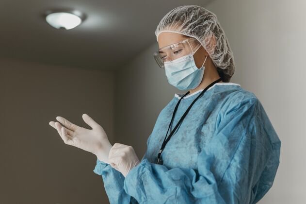 医院医生戴上手术手套穿着冠状病毒专家
