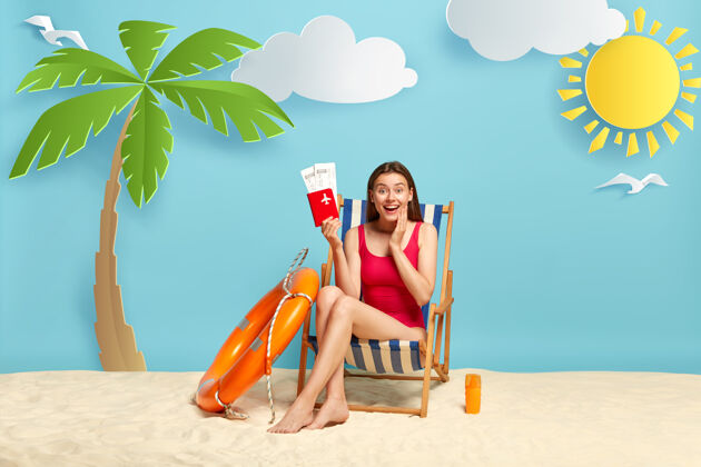 桑迪高兴的女旅客坐在沙滩椅上 拿着护照和机票浴衣比基尼积极