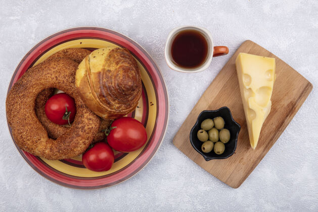 三明治上图是一个盘子上的小面包 上面放着新鲜的西红柿 橄榄和奶酪 背景是白色的木制砧板木头西红柿白