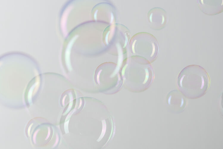 泡沫透明的肥皂泡图案在灰色的墙纸上圆抽象球体