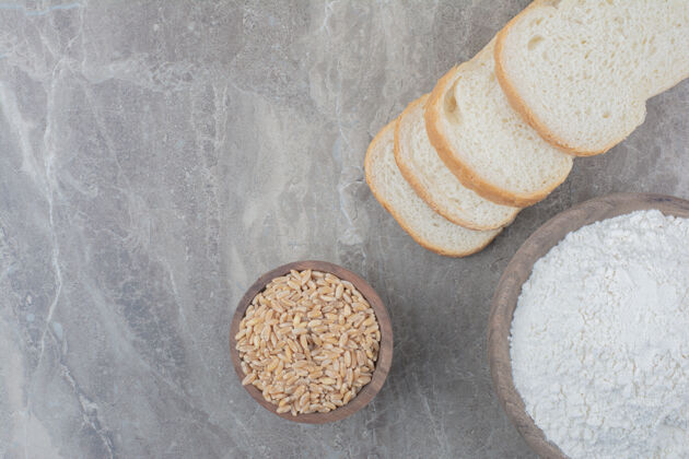 面粉一条白面包 大理石背景上有燕麦和面粉燕麦面包糕点
