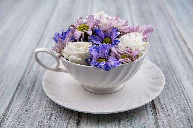 风景木制背景上茶碟上杯子里的花朵侧视图碟子杯子壁板