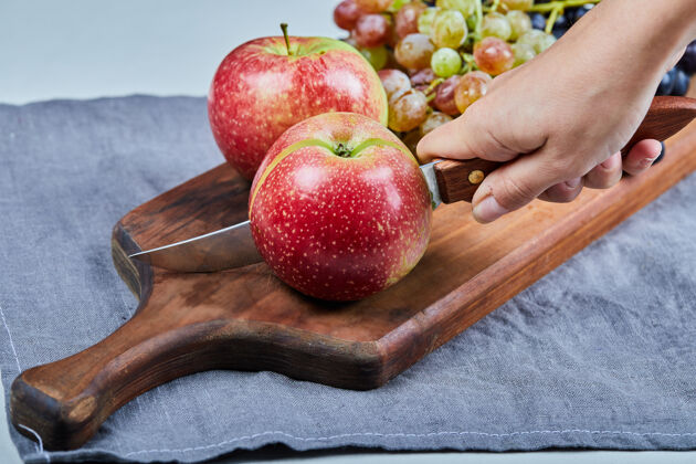 热带红苹果和葡萄串在木板上成分拼盘素食