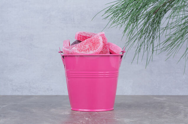 桶粉红色的桶 大理石背景上有糖果酱食物粉色果冻