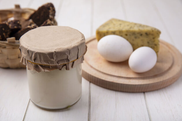 酸奶前视图酸奶在一个罐子里 奶酪和鸡蛋放在一个白色背景的架子上罐子鸡蛋早餐
