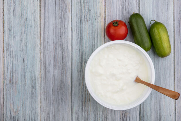 食物顶视图复制空间酸奶在碗与木勺番茄和黄瓜在灰色背景勺子空间灰色