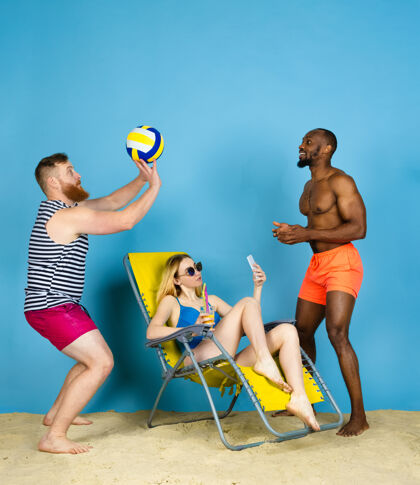 年轻人活动时间快乐的朋友自拍 在蓝色工作室背景下打排球人类情感的概念 面部表情 暑假或周末寒冷 夏天 海洋冰淇淋面部波浪