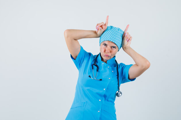 头身穿蓝色制服的女医生 手指举过头顶 看起来很滑稽 正面图诊所实验室立场