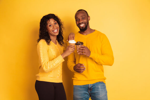 微笑年轻感性的非裔美国人 穿着黄色背景的明亮休闲服美丽的情侣人类情感的概念 面部表情 关系 广告一起喝咖啡人类头发金融