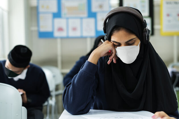 学生戴着面具在教室里学习伊斯兰感染面罩