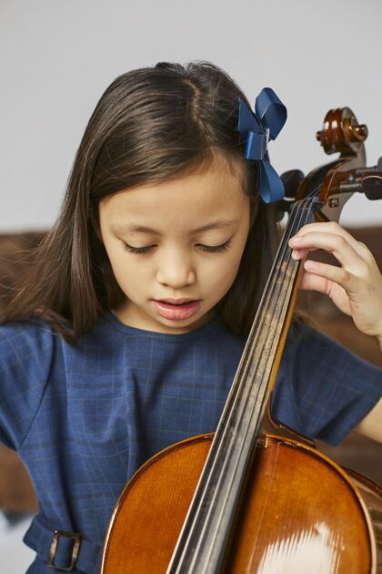 艺术年轻可爱的女孩学习大提琴艺术家天才孩子