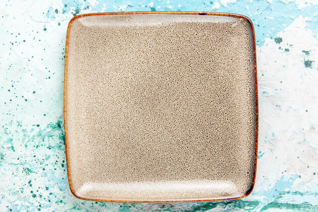 形状顶视图浅蓝色背景上形成的空棕色盘子正方形厨房餐盘餐具视图餐具背景