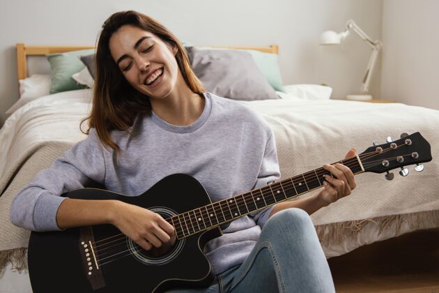 逗留笑脸少女在家弹吉他室内休息时间吉他