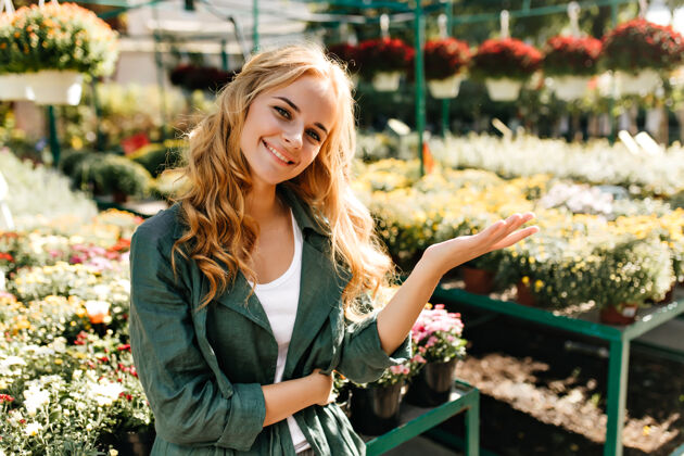 配件一位金发碧眼 笑容温柔的年轻女子 身着绿色长袍 系着腰带 正在温室里工作植物学家花享受