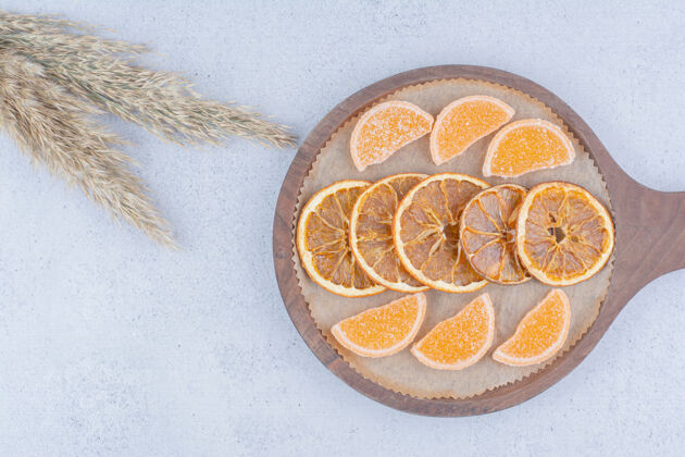零食把橘子片和果酱放在木板上糖果美味橙子