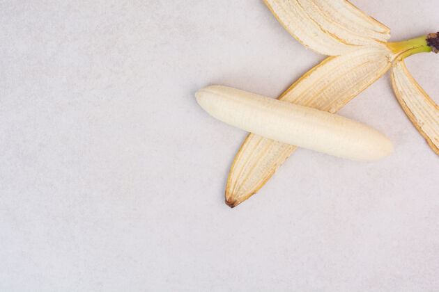 甜白桌子上剥皮的香蕉成熟零食果皮