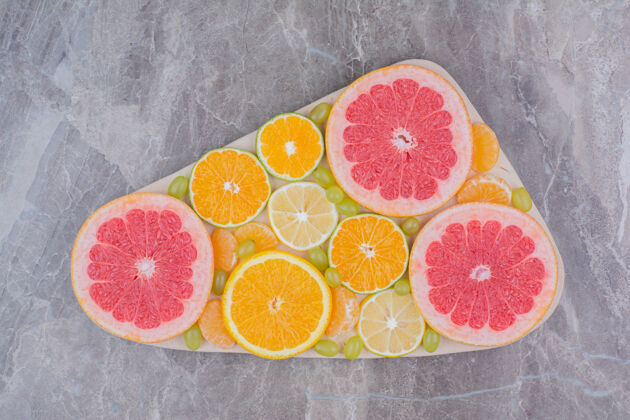 葡萄木板上柑橘水果片和葡萄的俯视图健康水果天然
