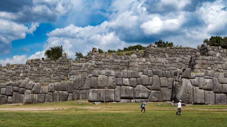 纪念碑古老的石墙和游客在它附近有一片蓝天景观欧洲废墟