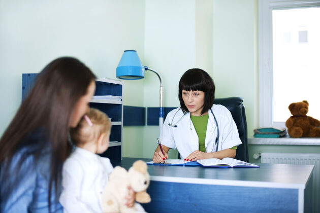 父母妈妈和女婴在医生办公室体检工作疾病