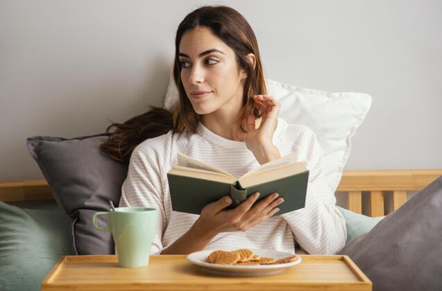 书籍女人在家看书吃早餐的正面图逗留休息时间逗留