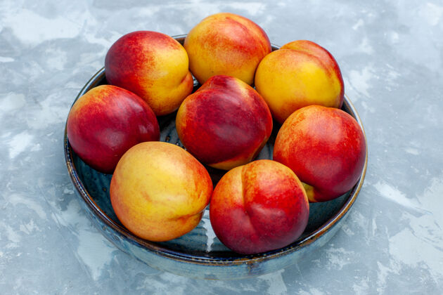 桃子在浅白的桌子上可以看到新鲜的桃子和美味的夏日水果可食用的水果食物维生素