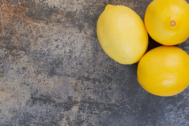 切片三个新鲜的柠檬放在大理石空间里半果汁酸橙