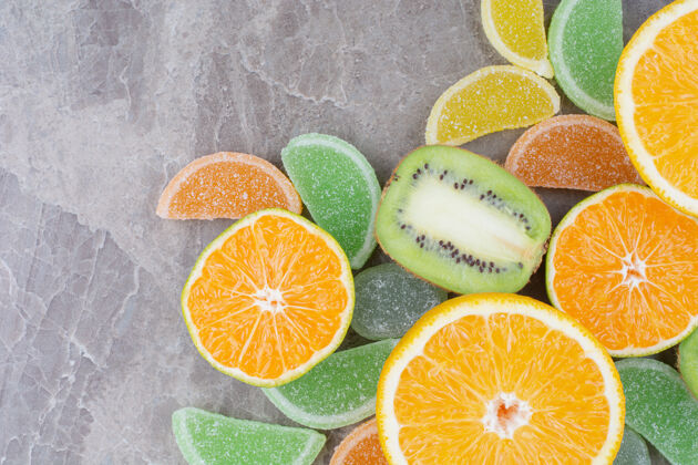 柠檬新鲜水果和甜甜的果酱在大理石背景上食物橘子糖果