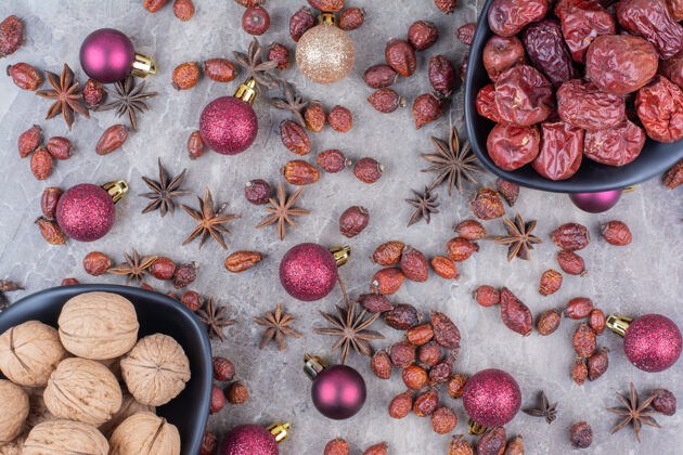 圣诞节核桃和玫瑰果和圣诞球一起放在碗里玫瑰果小吃坚果