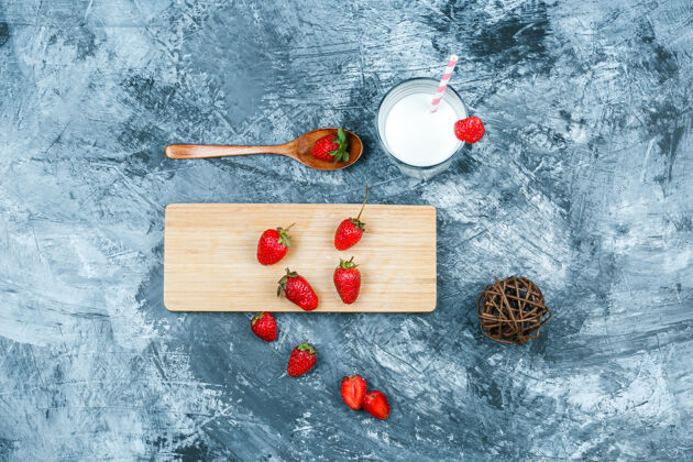 整个俯视图草莓与牛奶 提示和深蓝色大理石表面上的木勺砧板水平种子特写水果