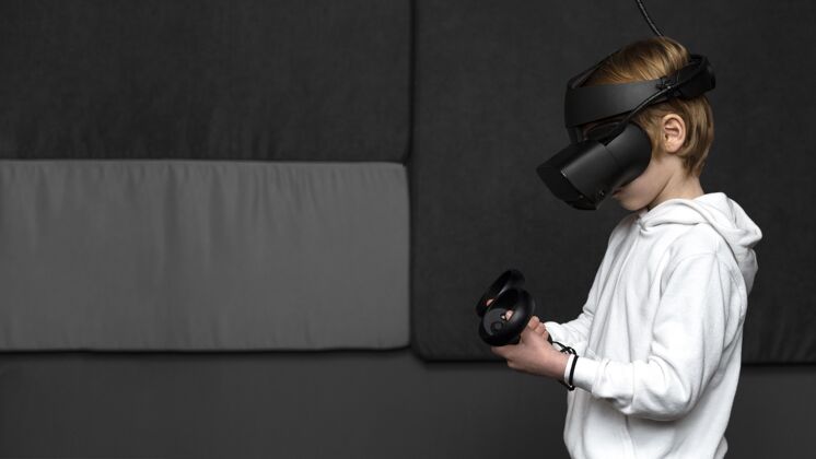 复制空间侧视图的小男孩使用虚拟现实耳机与复制空间青年儿童电子
