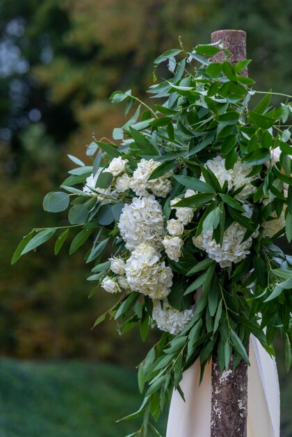 新娘美丽的花卉装饰与白色花瓣的鲜花在婚礼大厅蝴蝶结玫瑰鲜花