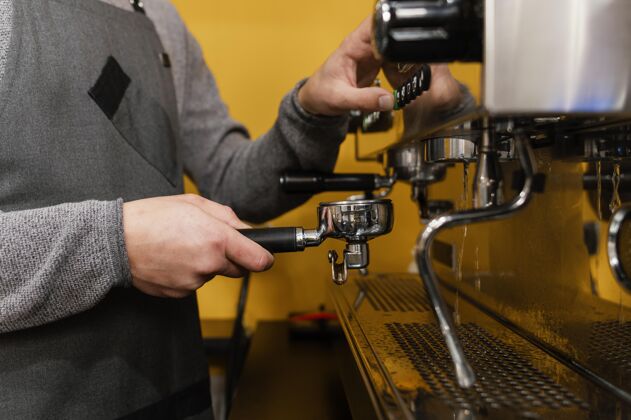 职业男咖啡师侧视图 带围裙 使用专业咖啡机水平咖啡馆工作