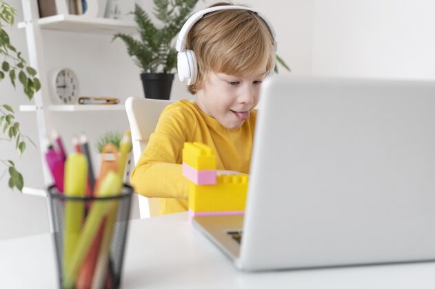 年轻人小男孩在家里用笔记本电脑和耳机爱好娱乐业余爱好