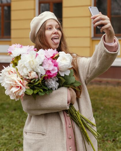 花束春天 女人在户外捧着花束自拍植被花智能手机