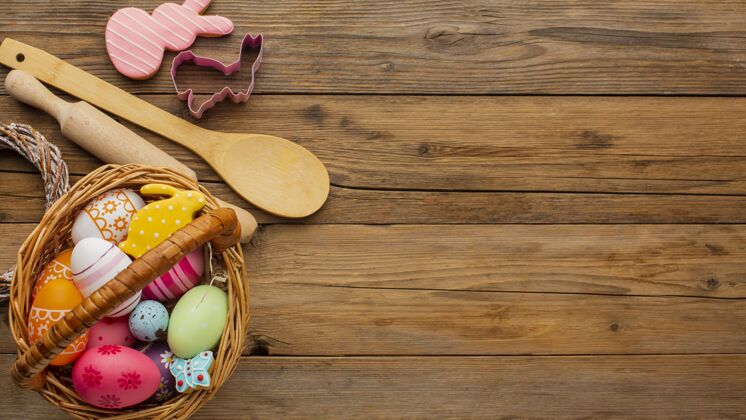 多彩顶视图彩色复活节彩蛋篮子与厨房用具和复制空间静物鸡蛋兔子