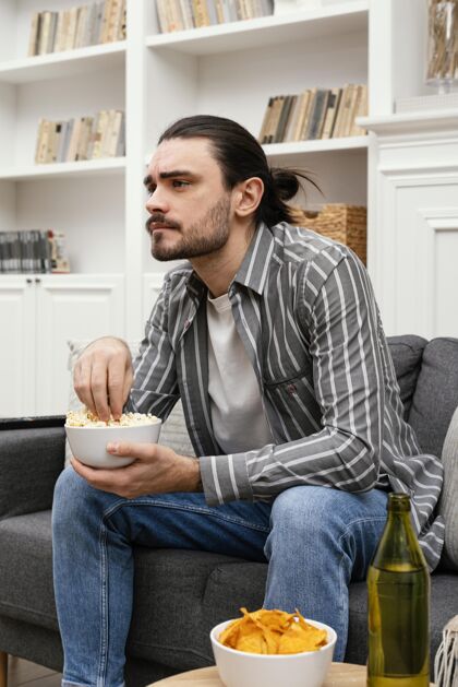 男性吃爆米花看电视的男人侧视图无忧无虑生活方式美好时光