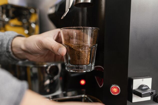 咖啡馆男咖啡师用机器磨咖啡工作雇员职业