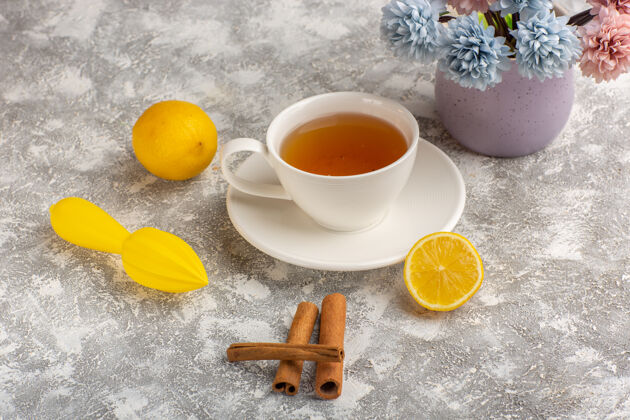 前面前视一杯柠檬肉桂茶 放在浅白的书桌上瓷器柑橘柠檬
