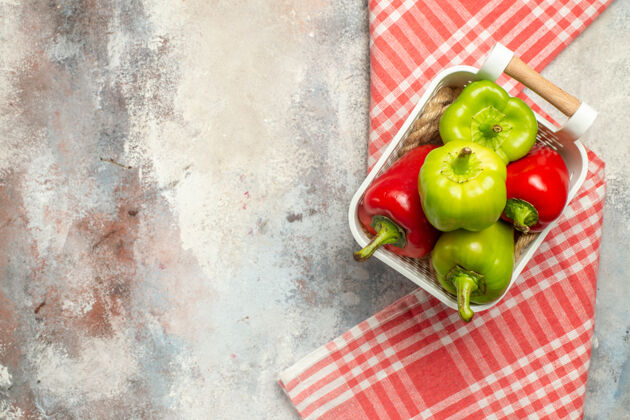 甜椒顶视图绿色和红色辣椒在塑料篮红白格子桌布裸体表面与自由空间青椒方格番茄
