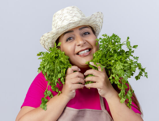 女人围裙戴帽子的中年园丁 手里拿着新鲜的草药围裙草药欢呼